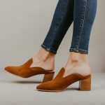 A pair of brown mules shoes for women.